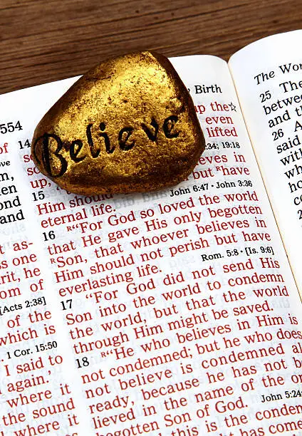 Photo of Religious: open Bible Scripture of John 3:16 with Believe stone