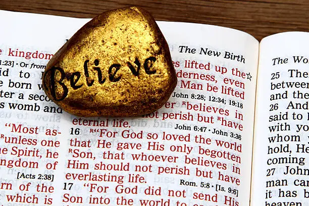 Photo of Religious: open Bible Scripture of John 3:16 with Believe stone