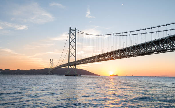 sonnenaufgang in der akashi kaikyo-ohashi-brücke - kobe bridge japan suspension bridge stock-fotos und bilder