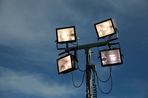 Close up of four illuminated portable lights. Lit up to illuminate a work site.