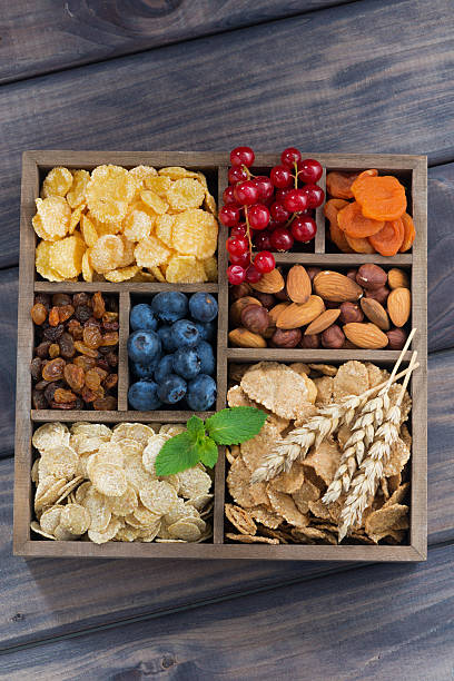 istock breakfast cereal, dried fruit, berries and nuts in wooden box 505166724