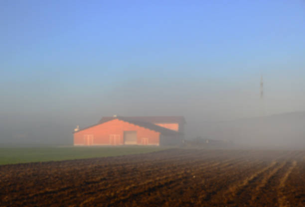 Abstract blur feding red barn on farm with blue sky in winter