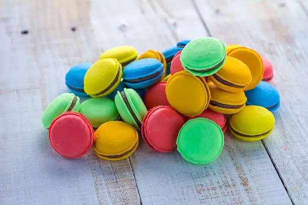 Colorful macarons on vintage pastel background. Macaron or Macaroon sweet meringue-based confection.