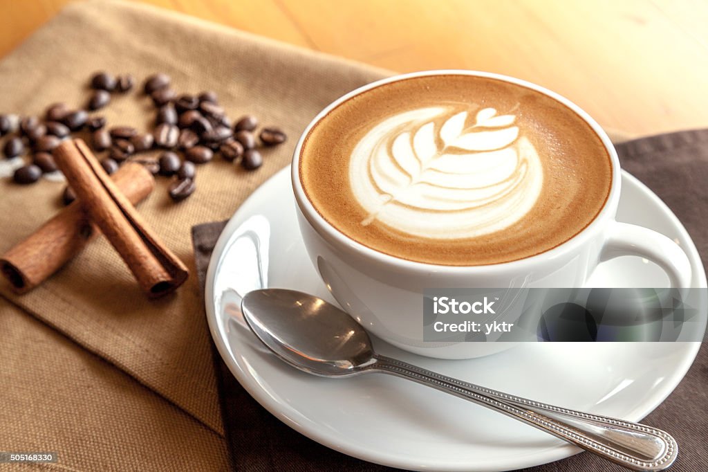 Cup of cafe' latte with coffee beans and cinnamon sticks Coffee - Drink Stock Photo