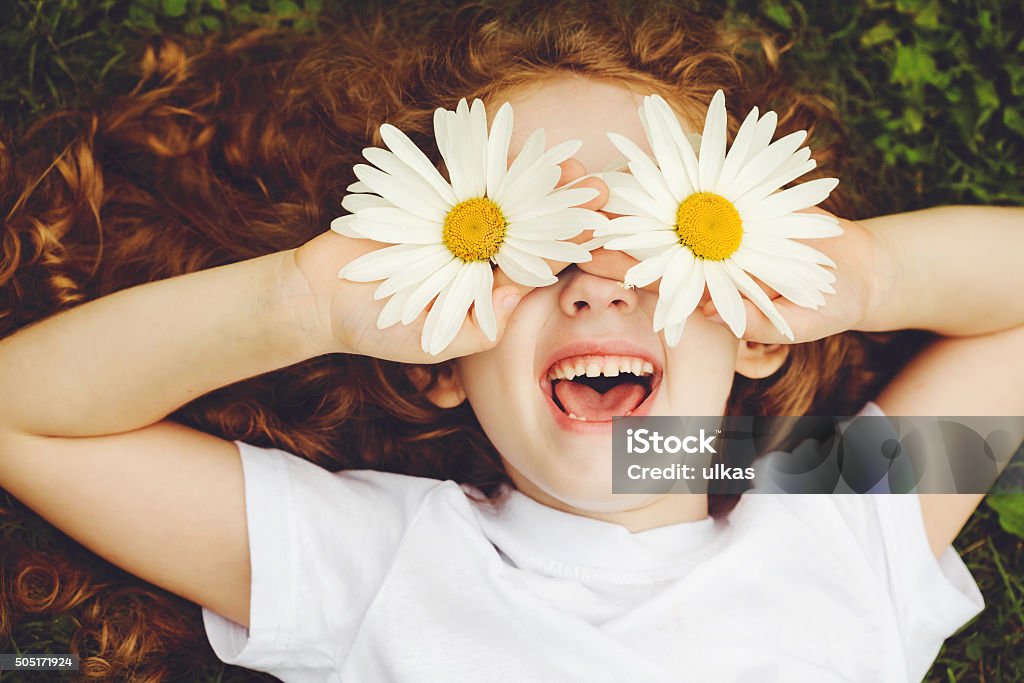 Child with daisy eyes. Child with daisy eyes, on green grass in a summer park. Child Stock Photo