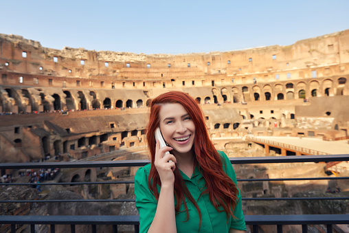 photo of joyful woman smiling and enjoying her day in Rome, listening the Colliseum history.