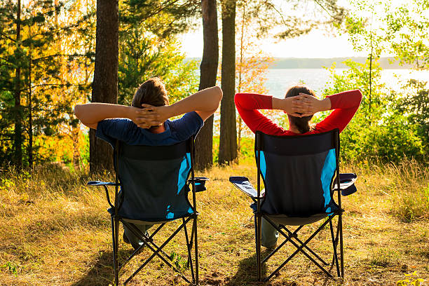 man and woman resting on the lake