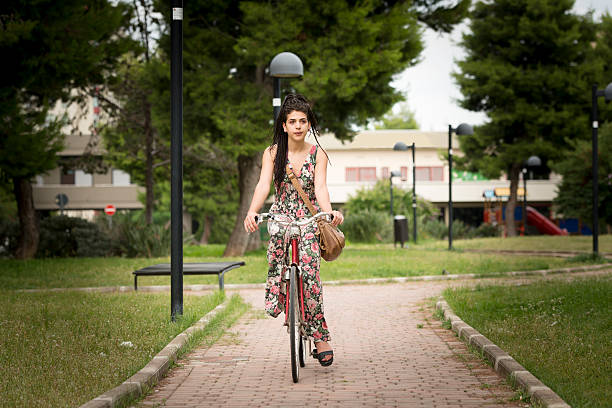 young Woman Riding a Bike in the Park stock photo