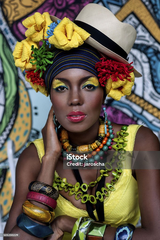 Portrait of an African girl on the background of the painting Portrait of an African girl on the background of the painting, in a hat with flowers Panama Hat Stock Photo