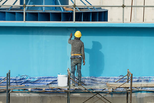 painting facade builder worker "movement" with roller at Water T stock photo