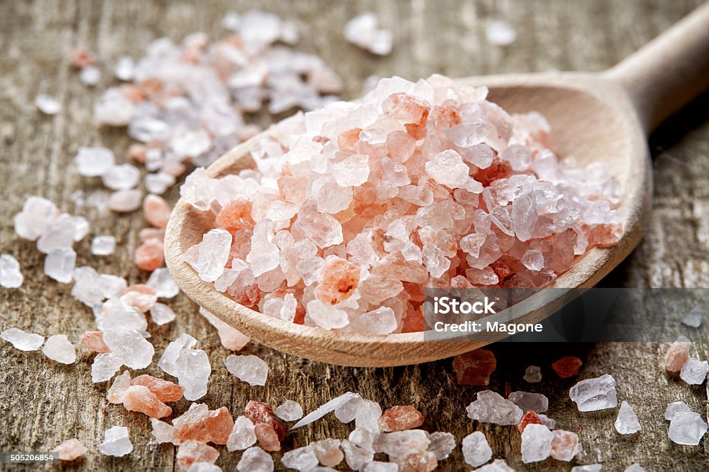 spoon of pink himalayan salt spoon of pink himalayan salt on wooden table Alternative Therapy Stock Photo