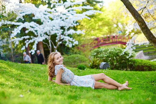 Beautiful young girl in cherry blossom garden on a spring day