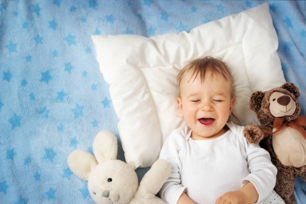istock One year old baby with alarm clock 505208318