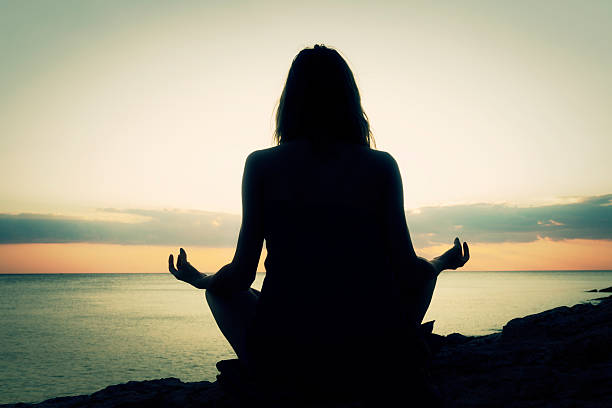 istock Young woman practicing yoga on the beach. 505208516