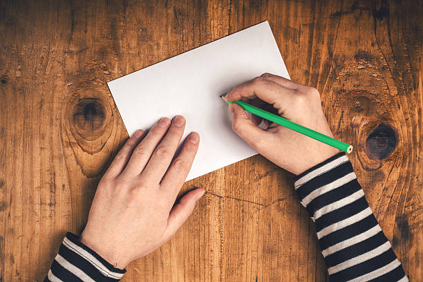 istock Woman writing recipient address on mailing envelope 505210618