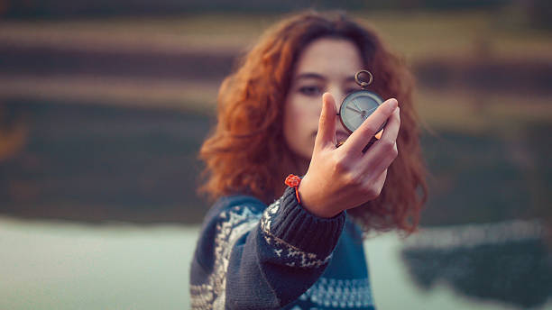 Teenager girl holding an old compass in hand stock photo