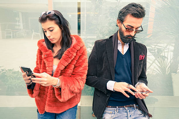 istock Hipster couple in sad moment ignoring each other using smartphone 505212140