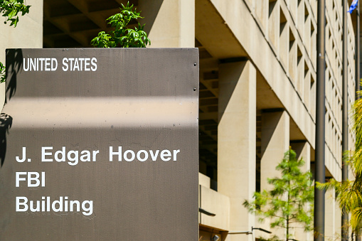 Washington DC, USA - May 2, 2015: Sign displaying J. Edgar Hoover FBI Building, in front of the Headquarters of the Federal Bureau of Investigation.