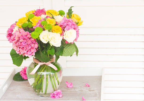 bouquet of pink hortensia , yellow and white fresh roses in vase  