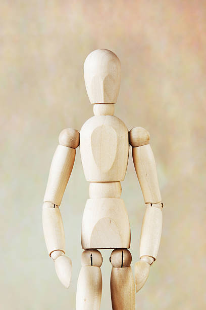 istock Wooden puppet model against brown background 505217118