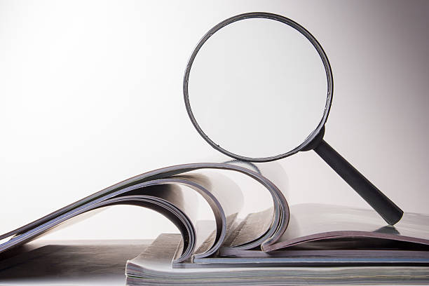 istock Architectural blueprints and blueprint rolls with magnifying glass 505217226