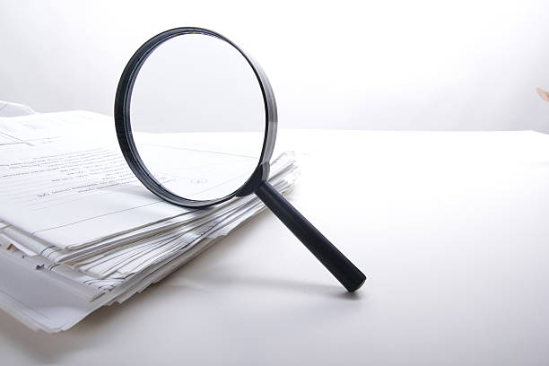 istock Architectural blueprints and blueprint rolls with magnifying glass 505217290