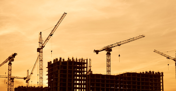 Construction site at dusk evening yellow back light, crane, photomerge