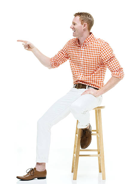istock Smiling casual man on stool and pointing 505218682