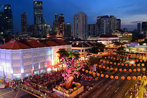 Singapore Chinatown street scene with old shophouses and Chinese New Year decorations. Crowds of people gathering for Chinese New Year carnival.