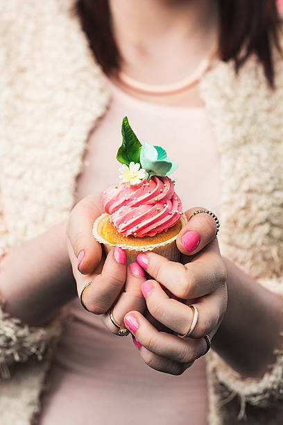 istock Girl holding pastel pink cupcake 505230494