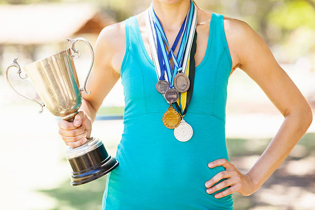 istock Athlete Holding Trophy And Wearing Various Medals 505232727