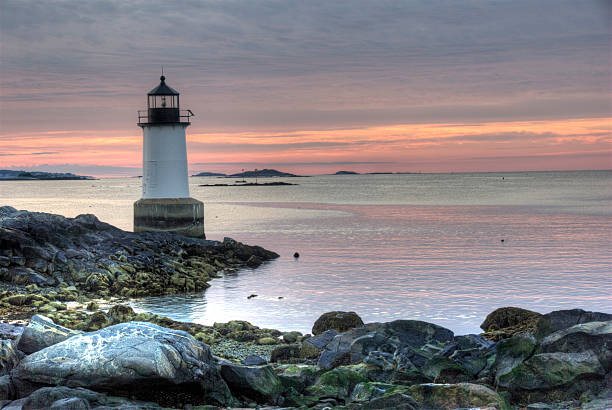 Fort Pickering Lighthouse in Salem, Massachusetts Rocky coastal shoreline with historical Fort Pickering Lighthouse.  Summer sunrise. salem massachusetts stock pictures, royalty-free photos & images