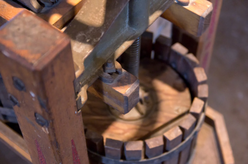 Close up view of an antique press used to extract the juice from grapes or apples for the production of wine or cider.