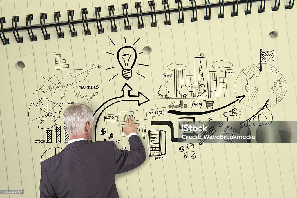 Rear view of businessman touching illustrations on huge notepad Rear view of grey haired businessman touching illustrations on huge notepad 50-59 Years Stock Photo
