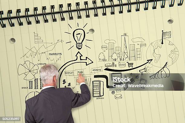 Rear View Of Businessman Touching Illustrations On Huge Notepad Stock Photo - Download Image Now