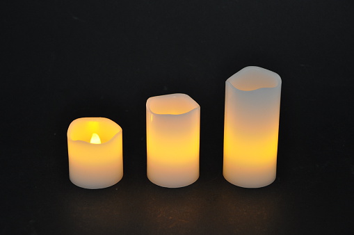 Burning pillar candle on a table