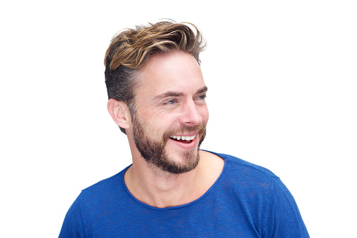 Close up portrait of a male model with beard laughing against white background