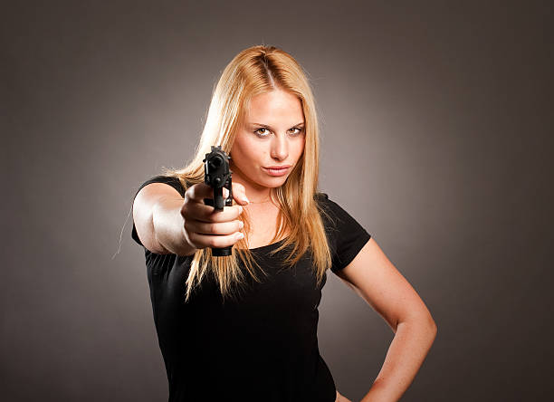 woman with a gun on gray background
