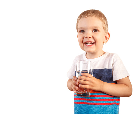 blond toddler boy holding glass with ice water. isolated on white