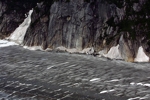 Norris Glacier, Juneau Icefield - Juneau, Alaska The Juneau Icefield is an ice field located just north of Juneau, Alaska and continues north through the border with British Columbia and is the fifth-largest ice field in the Western Hemisphere. The icefield is the source of many glaciers including the Mendenhall Glacier and the Taku Glacier. The icefield is home to over 40 large valley glaciers and 100 smaller ones.  alaskan icefield stock pictures, royalty-free photos & images