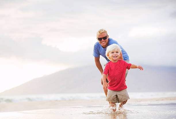 istock Father and son wallking on the beach 505249349