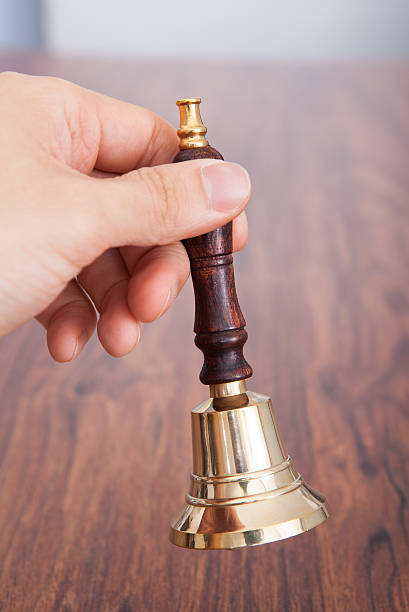 istock Person Hand On Wooden Table Holding Bell 505250153