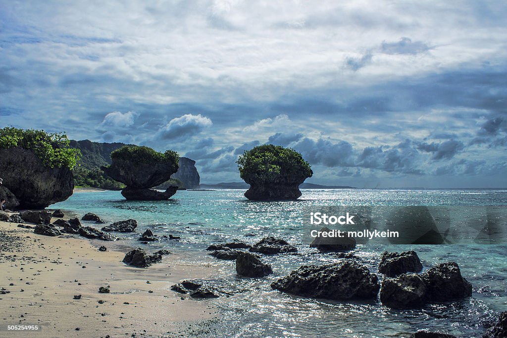 Large Rocks In Ocean A picture of a large rock in a beautiful ocean at Tanguisson Beach in Guam. Guam Stock Photo