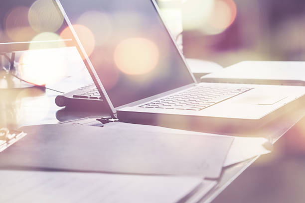 Laptop and papers on desk double exposure