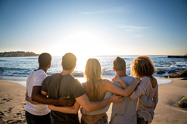 istock Friends looking at the sunset at the beach 505259360