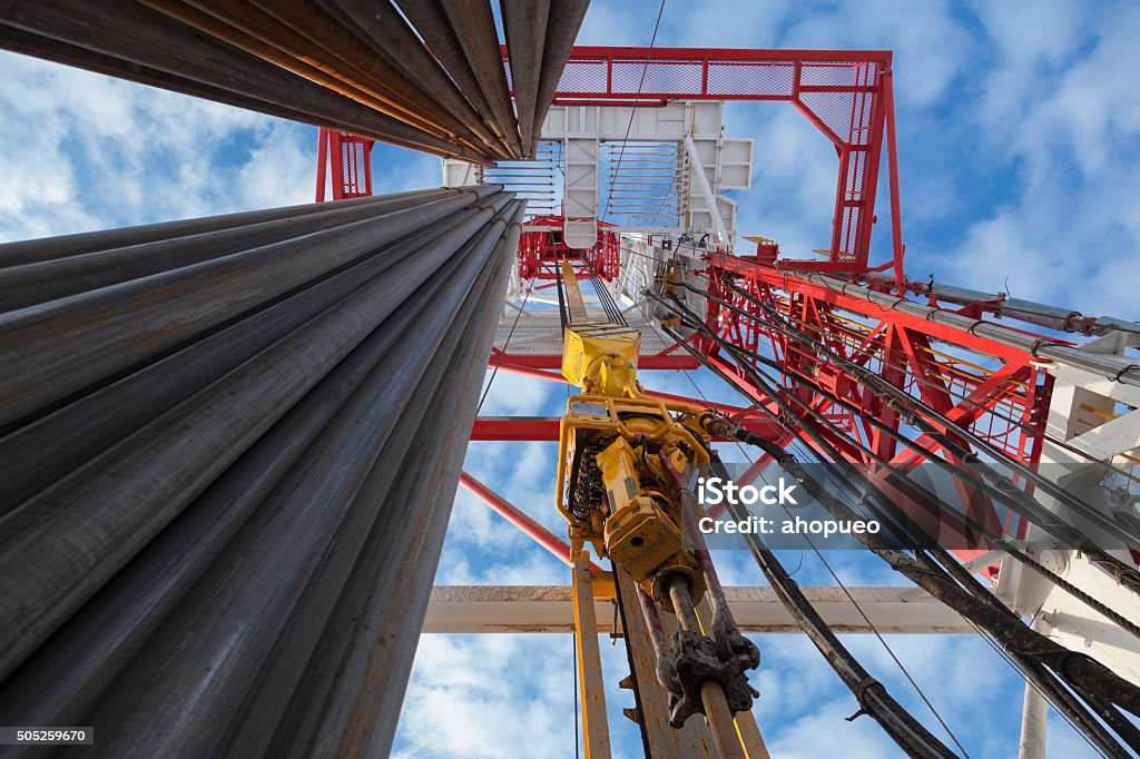 Oil rig with Pipes from bottom to top view Drilling rig view with Top Drive, many pipes, sky bottom up view in sunny weather in Siberia Drilling Rig Stock Photo