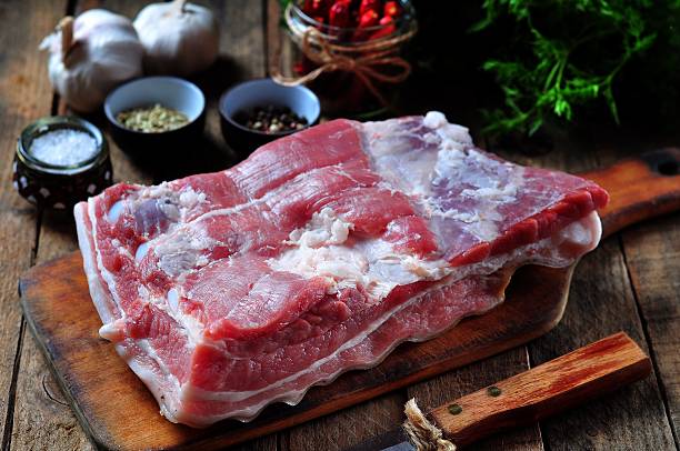 raw pork belly with salt, pepper, chili, fennel seeds, garlic stock photo