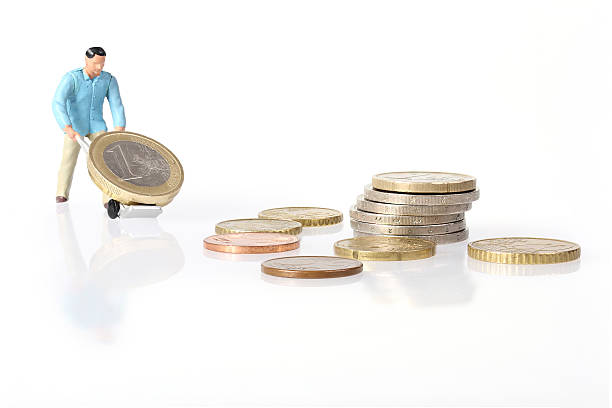 istock Miniature worker drives euro coins 505268302
