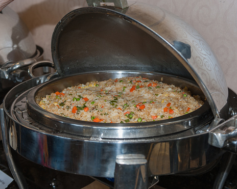 Shiny chafing dish keeps the rice and vegetable combo warm.
