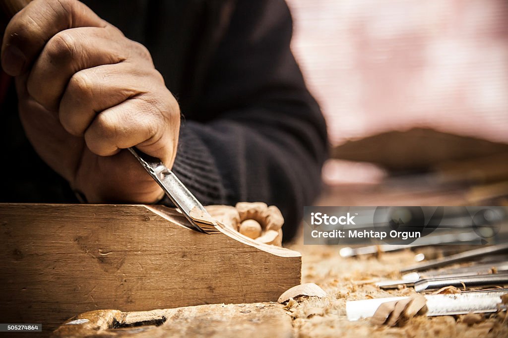 Engraver - Wood working An engraver is carving a piece of wood frame Wood - Material Stock Photo
